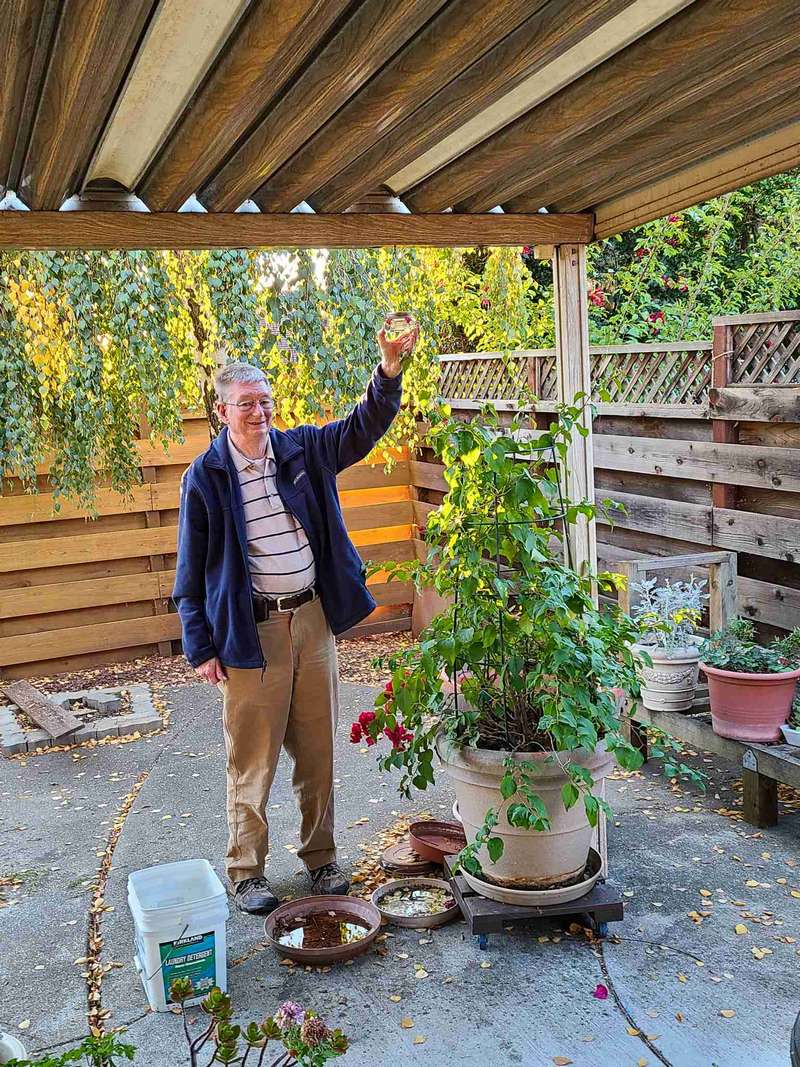Charles with hummingbird feeder and Bougainvillea plant