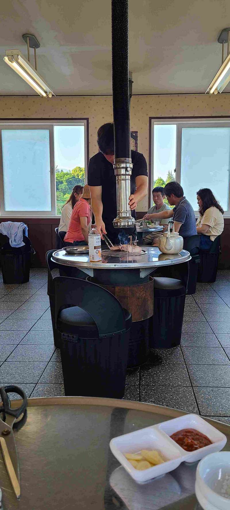 This is a restaurant that specializes in black pig.  The vent in the center of the table can be moved upward to be out of the way after the cooking is finished.
