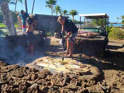 Preparing the traditional imu (underground oven) for the luau.