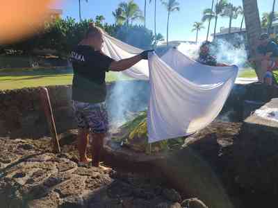 Covering the pit to let the slow-roasting begin.