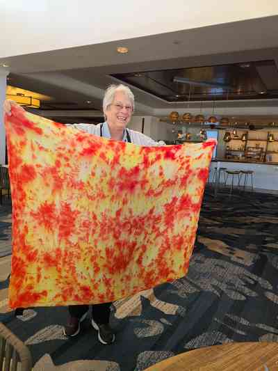 Helen showing off the vibrant tie-dye silk scarf she created in one of the resort's craft classes.