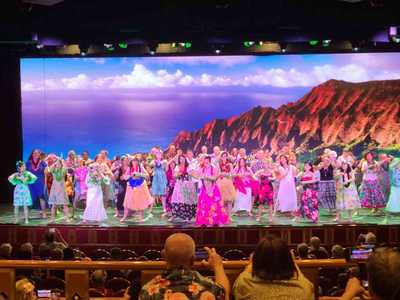 A vibrant Polynesian music and dance troupe brought on board for an evening show in Honolulu.