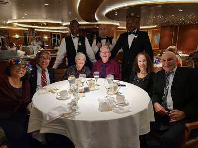 'Our Gang' at table 455: Doris, Vic, Helen, Charles, Rose, and Ron, flanked by servers Nene and Anesu.