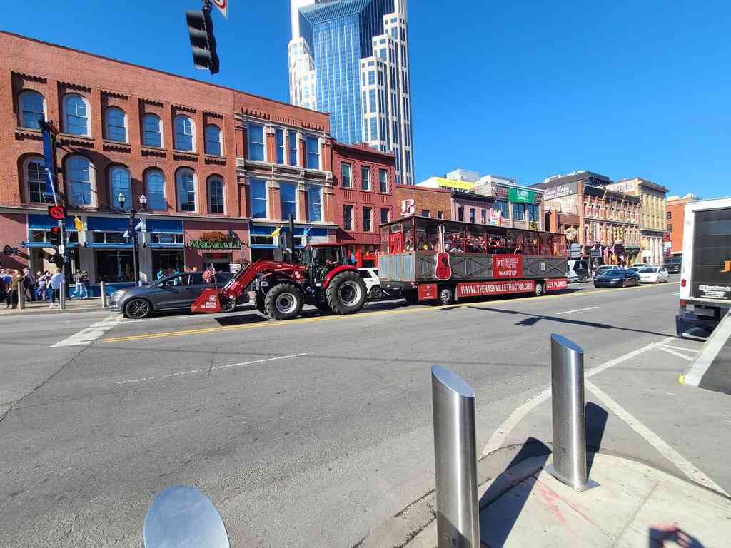 A mobile bar pulled by a tractor, alongside pedal-powered bicycle-stool bars cruising down the street!